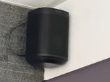 une enceinte noire accrochée au mur à côté d'un ordinateur portable