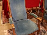 a blue chair that is sitting on a rug in a room