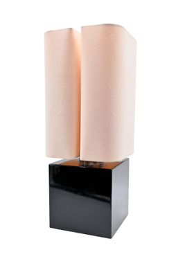 two black and white lamps sitting on top of a wooden block