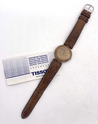 bracelet en cuir marron sur une montre à laquelle est attachée une étiquette
