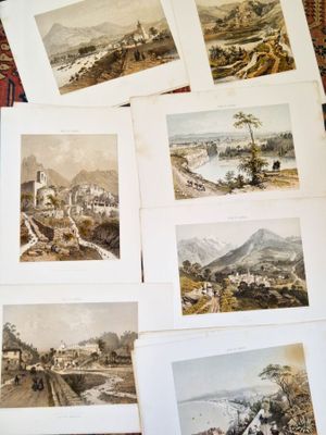 plusieurs photos représentant divers paysages, posées sur une table