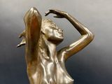 bronze statue of a woman holding her arms up