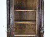 une vieille armoire en bois munie d'une porte vitrée