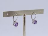 pair of amethorate and diamond earrings on a metal stand