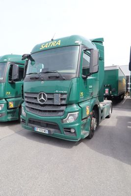 plusieurs camions verts garés les uns à côté des autres sur un parking