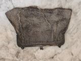 un sac à main en tricot marron posé sur un plan de travail en marbre