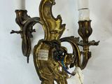 a wall mounted candle holder with two candles on it