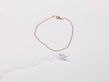 a close up of a gold bracelet with a tag on it