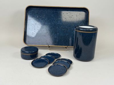 un récipient bleu avec quatre assiettes bleues à côté