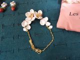 a bracelet with flowers on it next to a pink bag