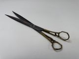 a pair of scissors sitting on a white surface