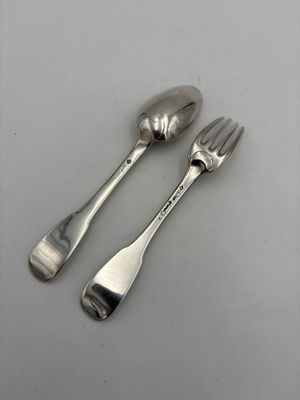 deux cuillères et une fourchette en argent sur une table