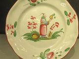 une assiette blanche ornée d'un motif rouge et vert