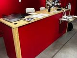 un bureau sur lequel se trouve un ordinateur portable, dans une pièce