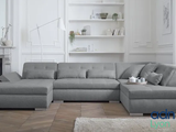 a grey sectional couch in a living room with a fireplace