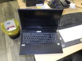 un ordinateur portable posé sur un bureau, à côté d'un clavier