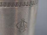 close up of a silver vase with a design on the bottom