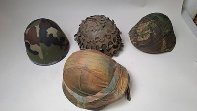 several military helmets are lined up on a white surface