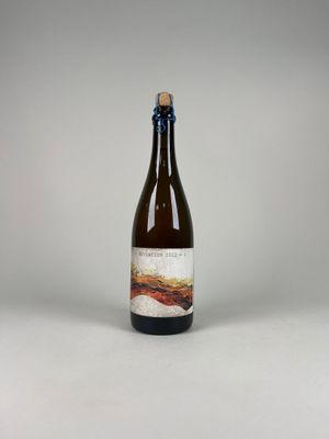 La bouteille de bière est posée sur la table, sur un fond blanc.