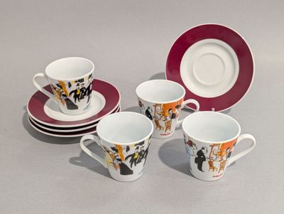 quatre tasses et soucoupes posées sur une table