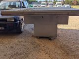 a truck that is parked next to a table in the dirt