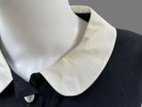 a mannequin wearing a black and white shirt with a white collar