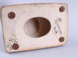 a white vase with a hole in it on a table