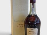 La bouteille de Martell Extra se trouve à côté de la boîte.