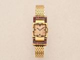 an image of a gold wrist watch with a pink face