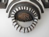 a zebra head with a pine cone in the middle of it