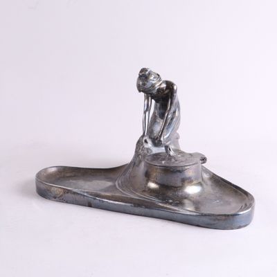 une sculpture en argent représentant un homme sur un bateau