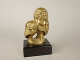 statue of a gold owl holding a baby on a black marble base