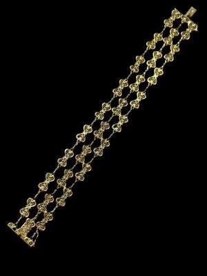 gros plan d'un bracelet en or sur fond noir
