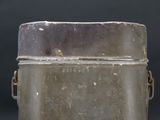 an old metal container with a lid on a table