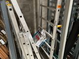 a ladder leaning against the wall next to a pile of wood