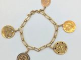 Gros plan sur un bracelet en or orné de pièces de monnaie