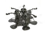 a metal sculpture of a bunch of objects on a white surface