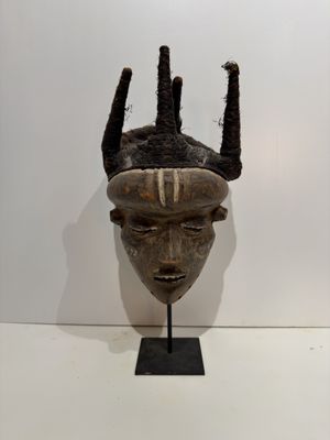 an image of a wooden mask with horns on a stand