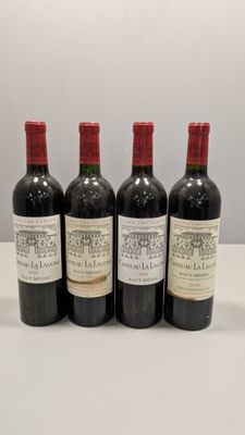 quatre bouteilles de vin sont alignées sur une table