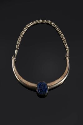 un collier en or et lapis-lazuli orné d'une perle de verre bleue