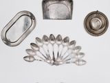 silver spoons, a mirror, and a tray on a white surface