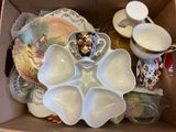 a cardboard box filled with dishes and cups and saucers