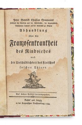 an old book that is open on a white surface