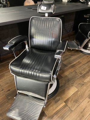 a black barber chair sitting in front of a mirror