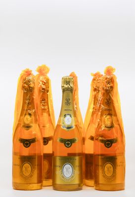 trois bouteilles de champagne sont alignées sur une surface blanche