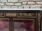 a cabinet with a marble top in front of a brick wall