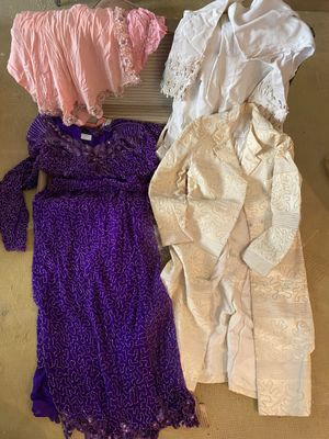 three dresses are laid out on the floor next to a heater