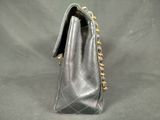 a close up of a black purse on a gray background