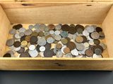 une boîte en bois remplie de pièces de monnaie posée sur une table