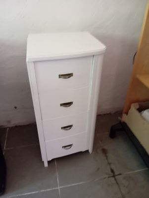une commode blanche posée à côté d'un lit dans une chambre